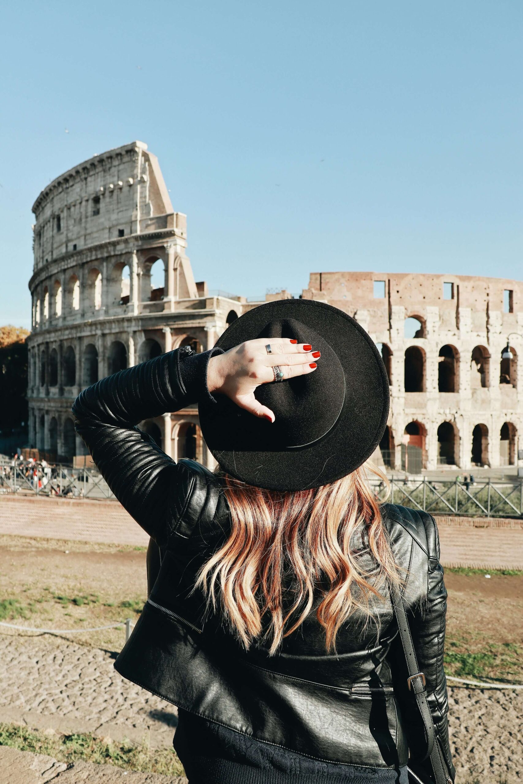 A woman is traveling alone to the colosseum in Rome.